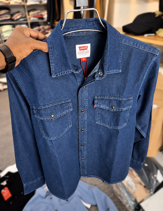 Blue denim shirt held on hanger