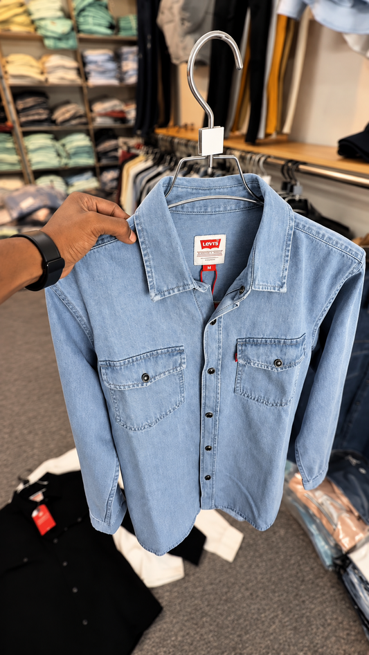 Light Blue denim shirt held on hanger